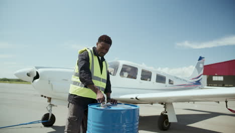 ground technician preparing fuel for aircraft service at outdoor airfield
