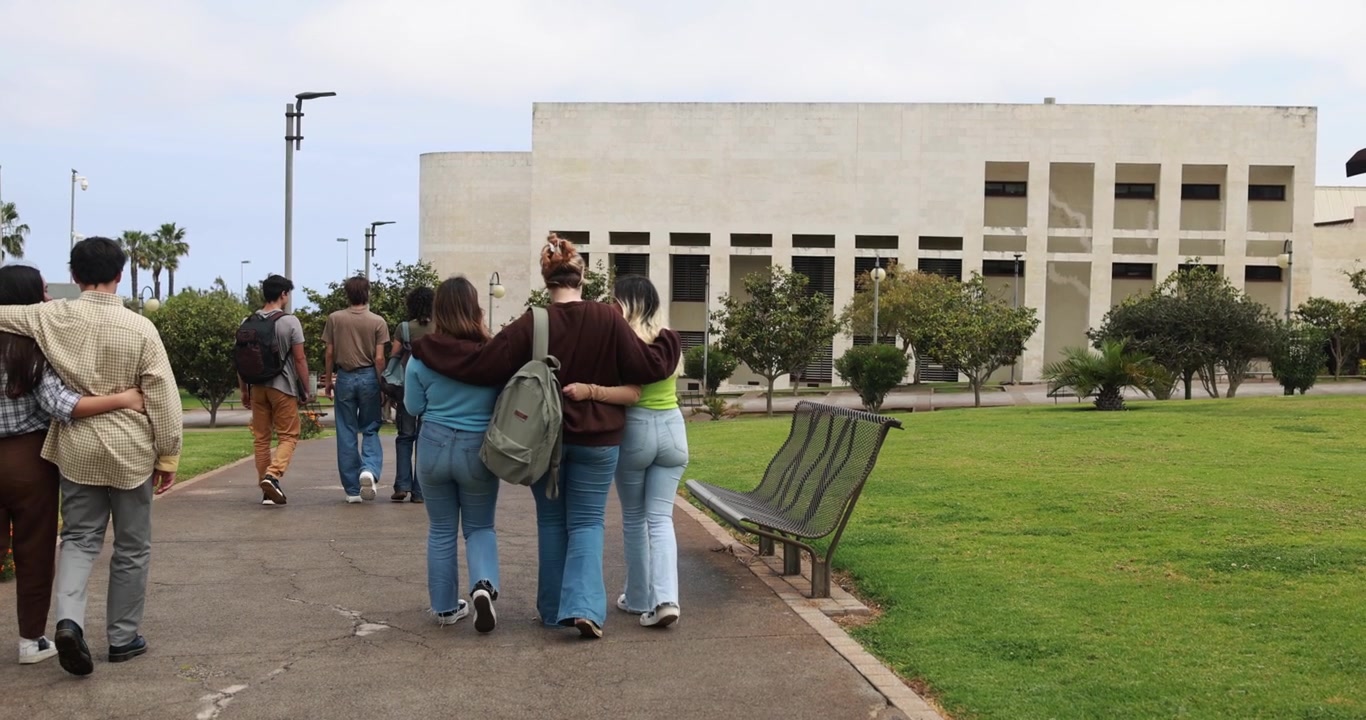 Gruppo di studenti che cammina insieme nel campus universitario