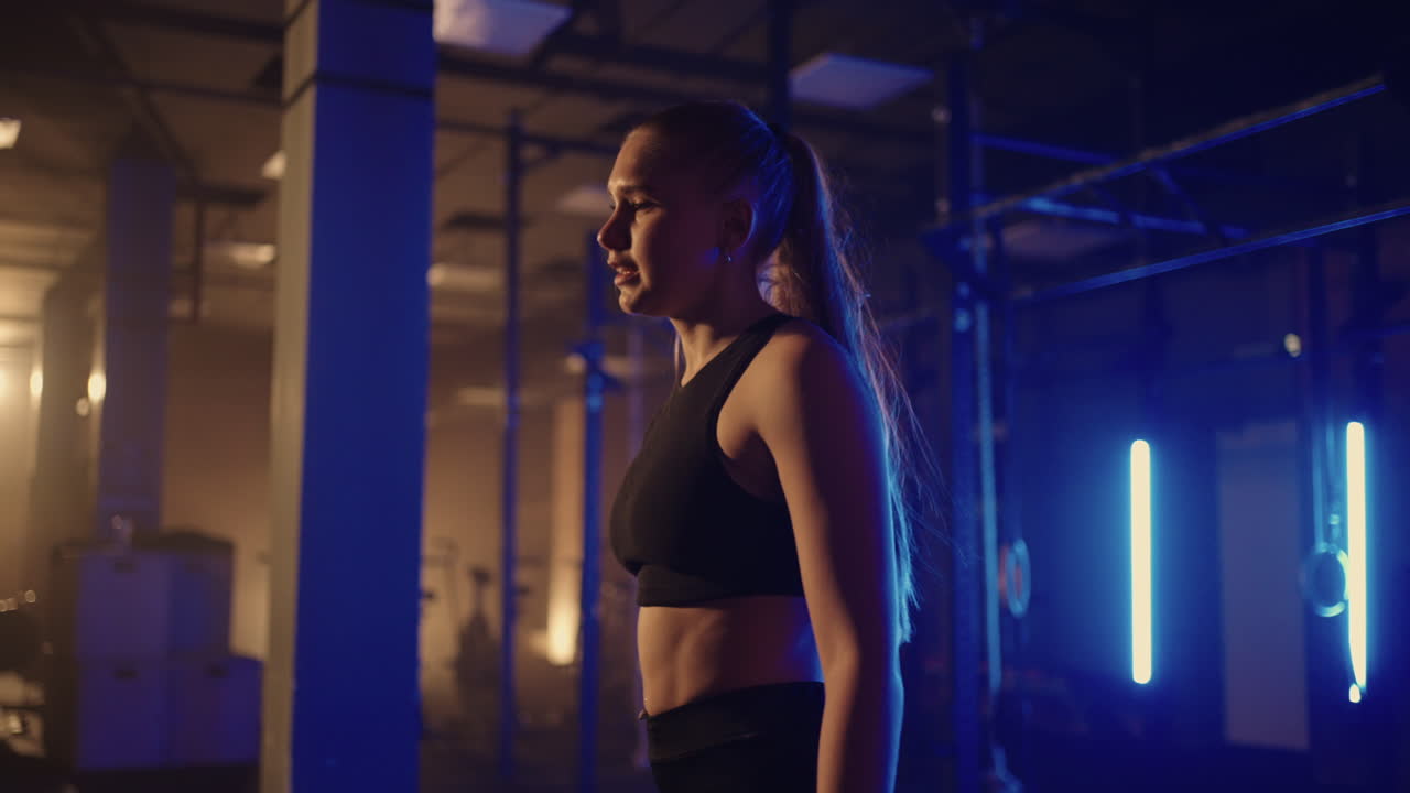 슬로우 모션: 피곤한 여성이 지구력 운동 후 훈련에서 힘을 회복합니다. 성공을 거두고 장애물을 통과하여 앞으로 나아갑니다. 강한 여성의 개념