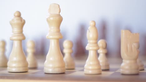 close up of focusiung from the white to the black chess figures on a wooden chessboard.