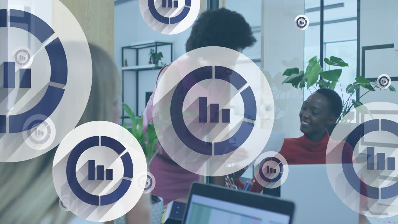 Animation of multiple graph icons over diverse female coworkers discussing reports in office