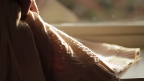 soft textures in natural light: a cozy knit blanket draped elegantly by the window, capturing the warmth and comfort of home decor