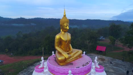 enorme estatua de buda en órbita de drones aéreos que se eleva en las montañas de laos tailandia