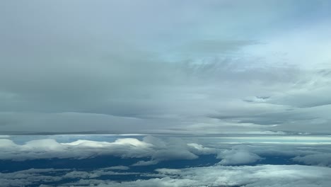vista aérea desde la cabina de un jet mientras volaba a 12000m de nivel de crucero a través de un turbulento cielo invernal cubierto de estratos y cúmulos
