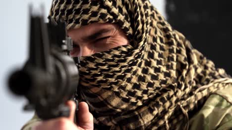 soldier with covered face aiming rifle