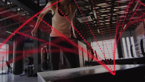 Animación-De-Una-Cadena-De-ADN-Sobre-Una-Mujer-Caucásica-Haciendo-Ejercicio-En-Un-Gimnasio-De-Boxeo