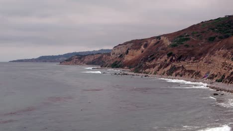 top down birds eye aerial view of the waves crashing on a rocky southern california beach