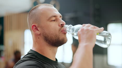 man drinking water at the gym