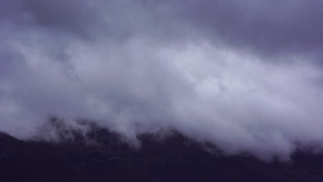 nubes que se elevan sobre la ladera de la montaña en el día lluvioso de invierno, lapso de tiempo