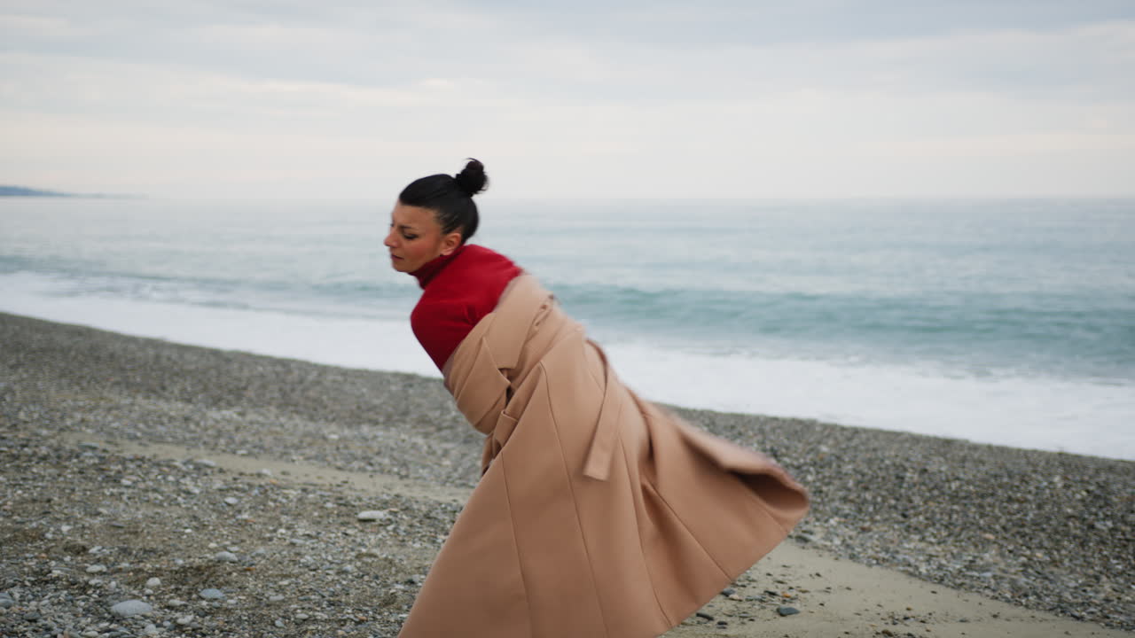 Woman Takes Off Brown Coat To Emotionally Free Herself From Problems At Beach