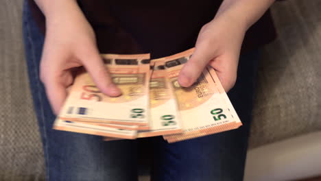 Top-view-of-a-woman's-hands-slowly-counting-money-bills