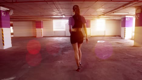 stunning , sexy model walking away from the camera in a parking garage with volumetric light streaing in the widows