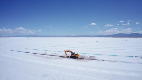 aerial of excavator extracting salt at salinas grandes in argentina