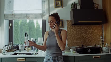 mujer hablando por teléfono en la cocina