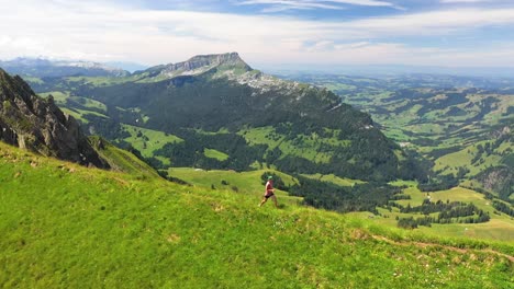 Drone-shot-panning-right-to-follow-a-healthy-runner-on-a-small-trail-on-Hardergrat-ridge-in-Switzerland