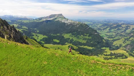 drone shot panning right to follow a healthy runner on a small trail on hardergrat ridge in switzerland