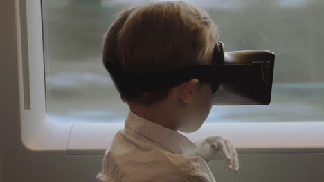 child having fun in the train with vr glasses