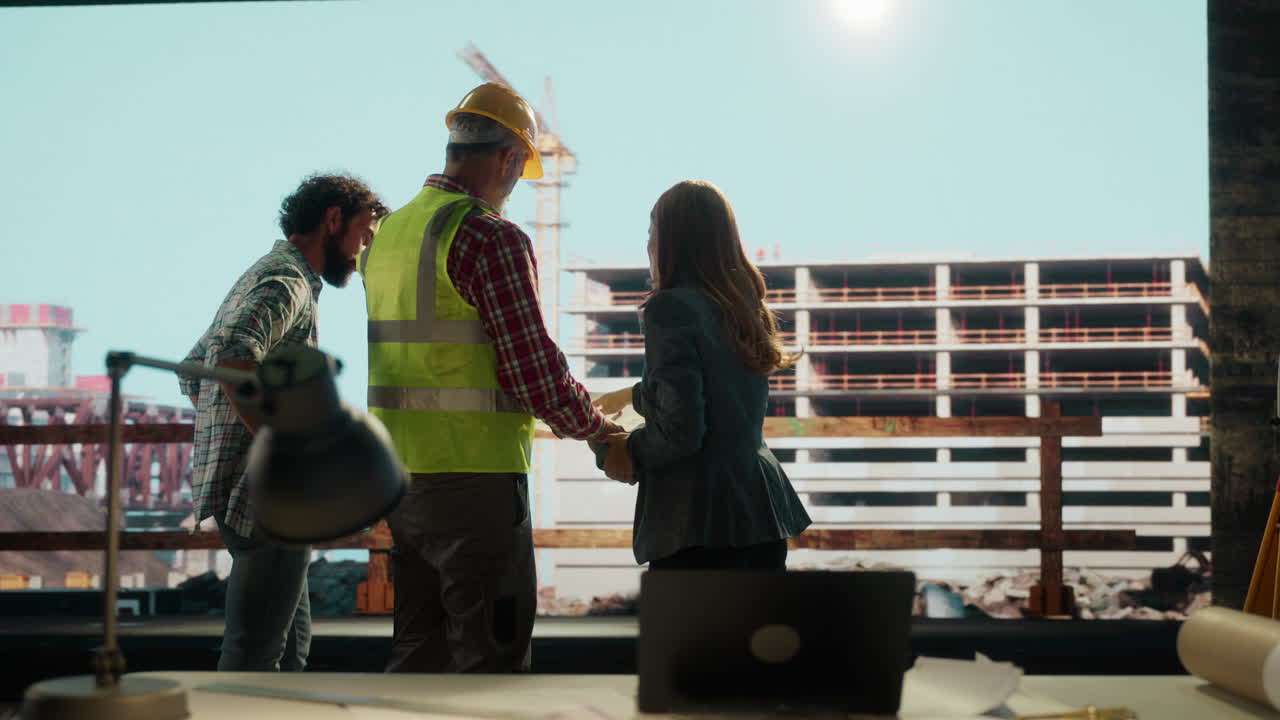 Construction team reviews blueprints at a building site