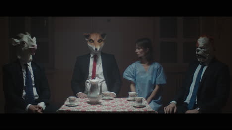 a girl sits at a table with strange figures in animal masks.