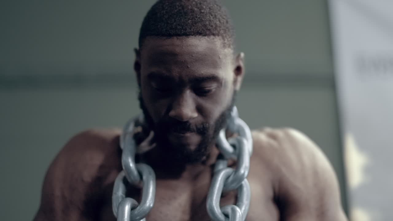 Intense shot of an African American man doing weighted Dips