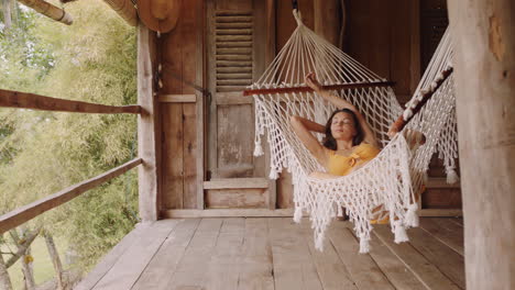 Mujer-Sexy-En-Hamaca-Disfrutando-De-Un-Estilo-De-Vida-Cómodo-De-Vacaciones-En-Un-Centro-Vacacional-Balanceándose-Pacíficamente-En-Un-Perezoso-Día-De-Verano-En-Una-Cabaña-Paradisíaca-Tropical