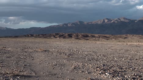 crushed rock gravel plain with sierra nevada background in death valley, california, aerial dolly right shot