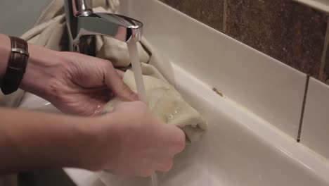 hombre limpiando la mancha del trapo en el grifo de agua - primer plano