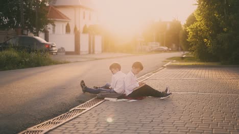 schoolboys-sit-on-street-sidewalk-surrounded-by-books