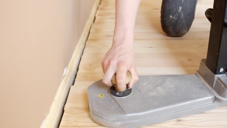 person using floor sanding machine during restoration, closeup