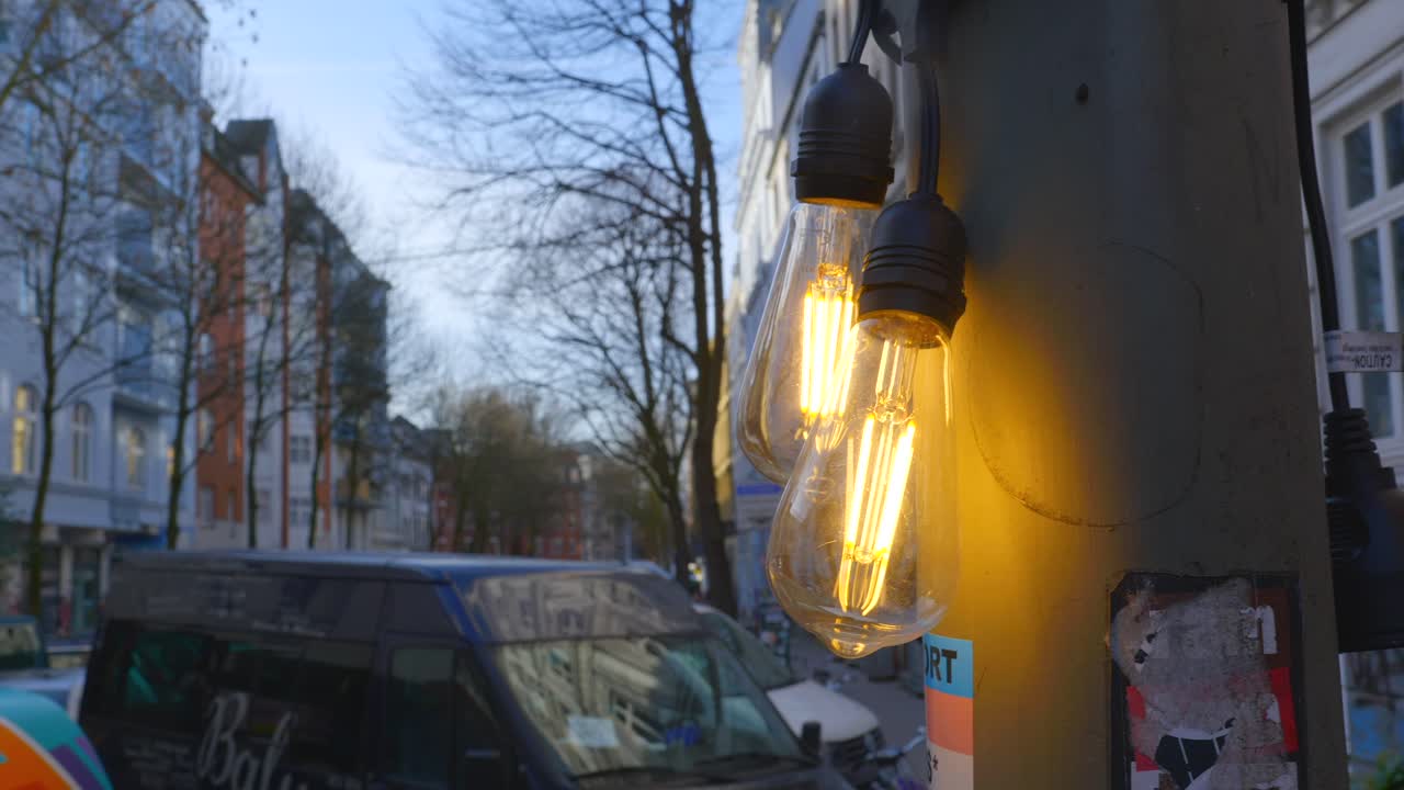 Glowing Edison Bulbs on a City Street at Dusk