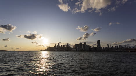 Sonnenuntergang-Im-Zeitraffer-Der-Skyline-Von-Toronto-Von-Der-Anderen-Seite-Der-Bucht-Am-Polson-Pier