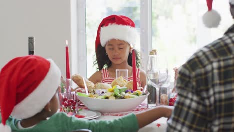 Feliz-Familia-Multigeneración-Afroamericana-Con-Gorros-De-Papá-Noel-Y-Celebrando-En-La-Cocina