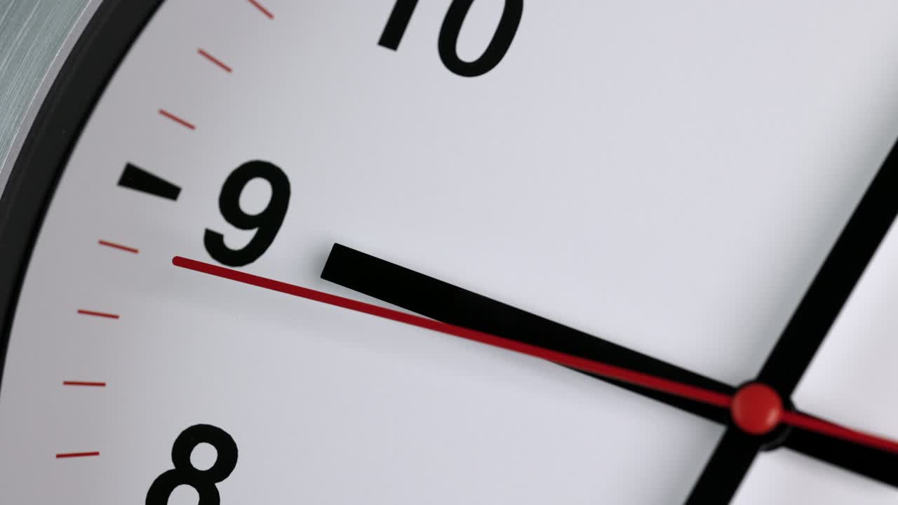 el gran reloj de pared blanco marcó la hora para las nueve. el minutero rojo sigue funcionando. película de lapso de tiempo.