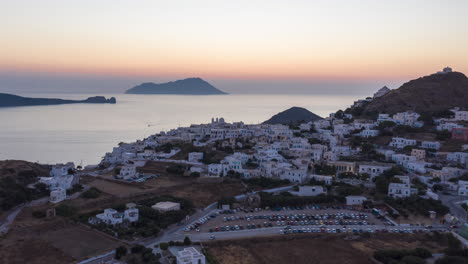 Aerial-Hyper-Lapse-above-Typical-Greek-Village-at-Sunset-overlooking-the-Aegean-sea,-Cyclades,-Greece