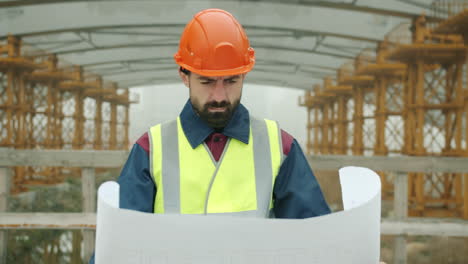 construction engineer reviewing plans on a construction site