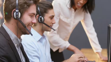 Smiling-customer-service-executives-talking-on-headset-at-desk-4k