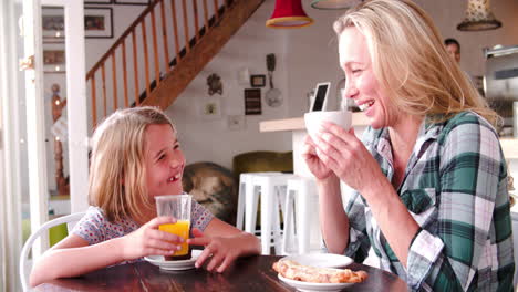 Madre-E-Hija-Hablando-En-Una-Mesa-En-Un-Café.