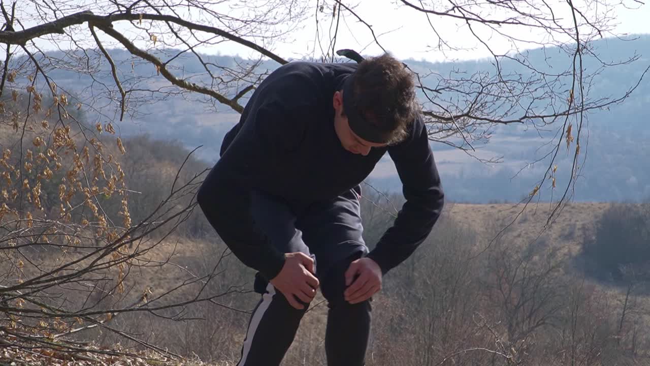 A ninja performs stretching exercises in a mountainous landscape, preparing for combat. His posture reflects discipline and focus amidst nature