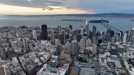 high-angle aerial of downtown san francisco skyline and oakland bay bridge at dusk