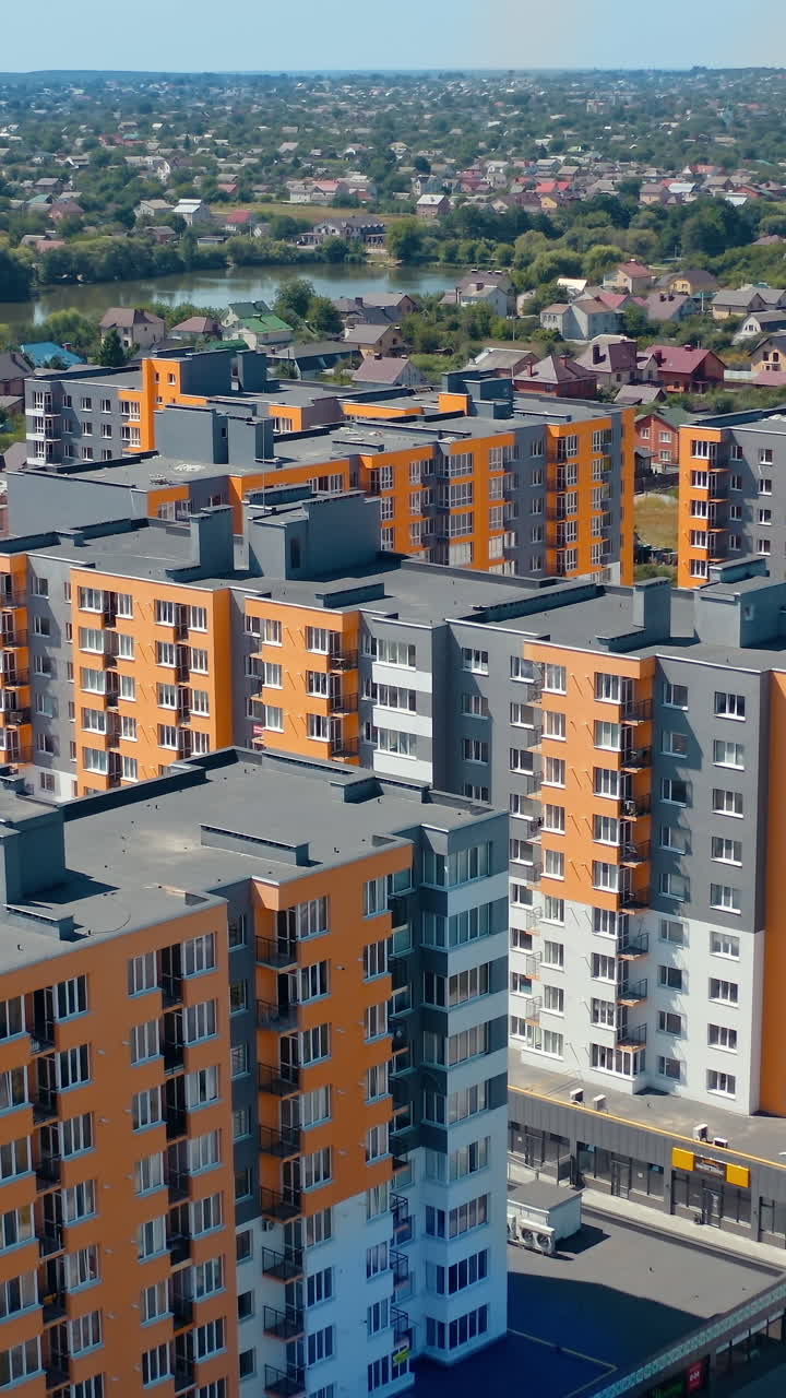 Residential complex with multi-storey buildings. Modern area with new skyscrapers in the outskirts of a city. Colorful architecture of urban housing. Aerial view. Vertical video