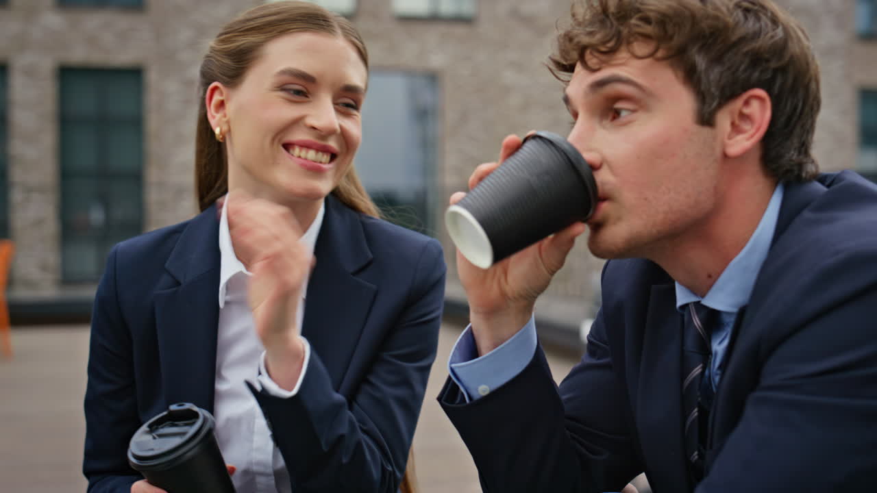 Businesswoman businessman sipping coffee at meeting at rooftop cafe closeup
