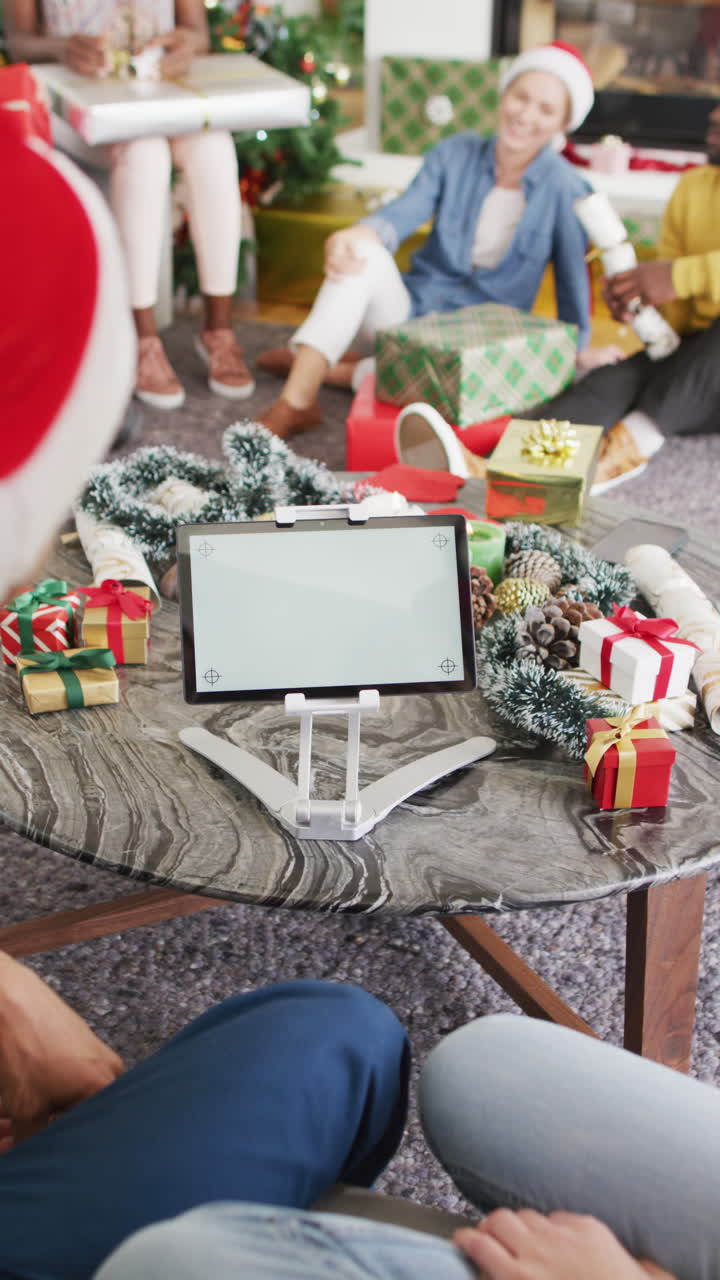 video vertical de diversos amigos en casa haciendo video llamada de tableta de navidad, copia espacio en la pantalla