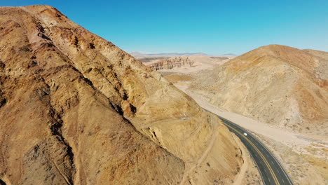 Natural-erosion-along-a-butte-in-the-Mojave-Desert-above-California-Highway-58---aerial-parallax-reveal