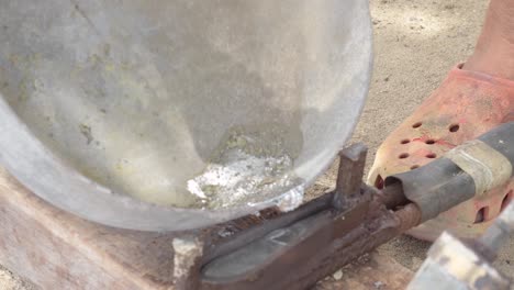 putting hot liquid lead from the bottom pot into mold to make fishing sinkers, closeup