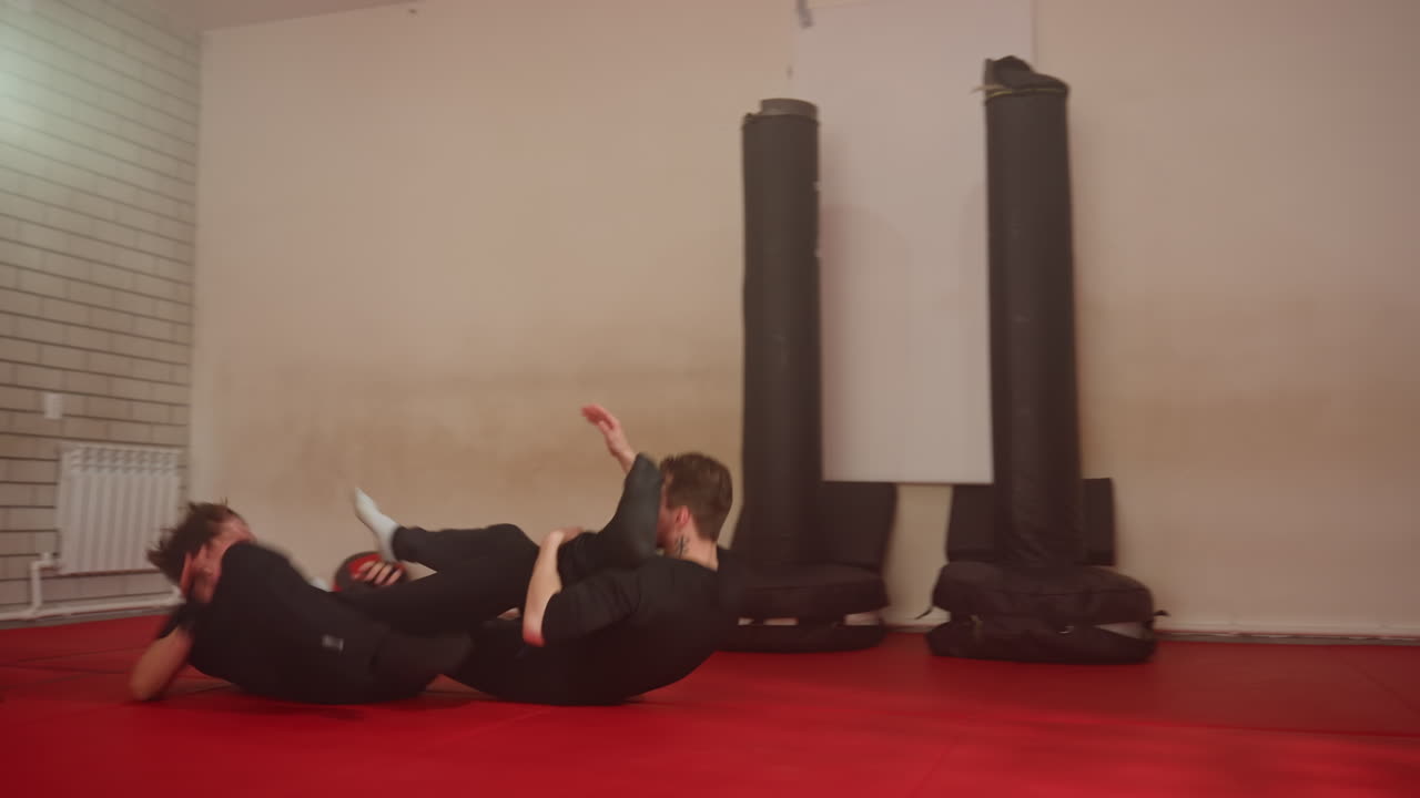 Boxer sparring session inside gym as two athletes face each other preparing for fight, wearing black sportswear, focusing on training, technique, combat skills, discipline, during martial arts