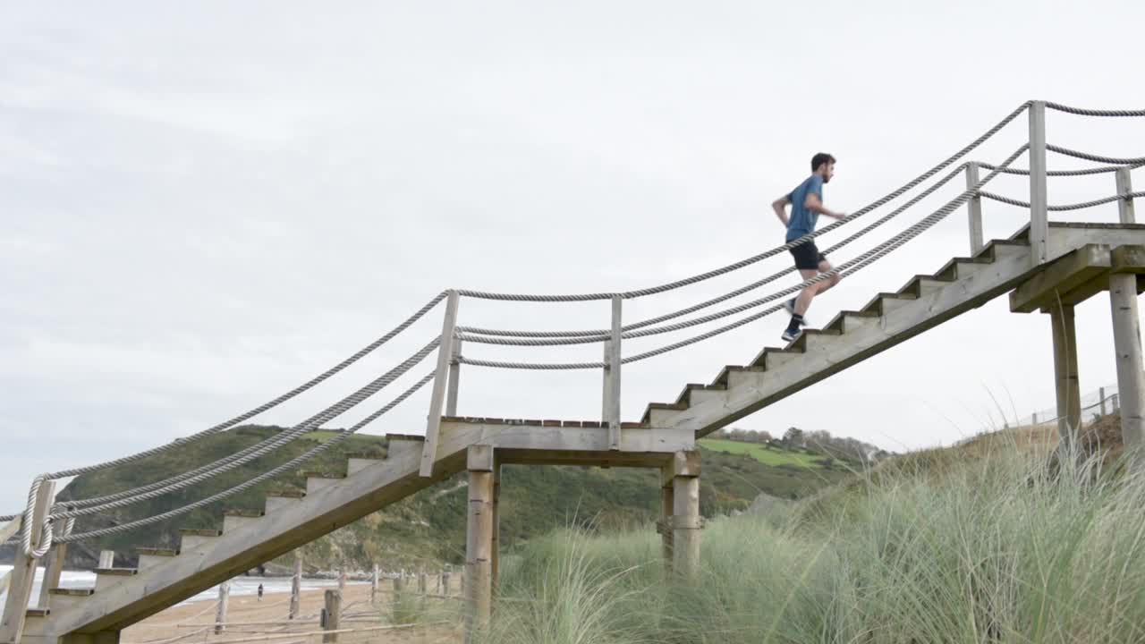 deportista corriendo por las escaleras en la costa con las montañas