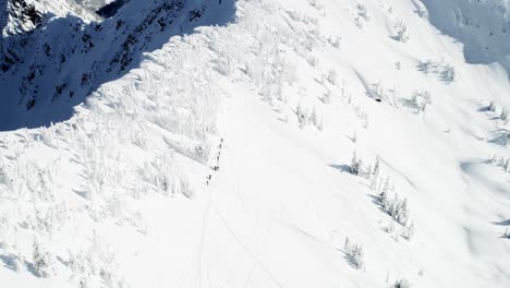 skiers walking on a snow capped mountain 4k