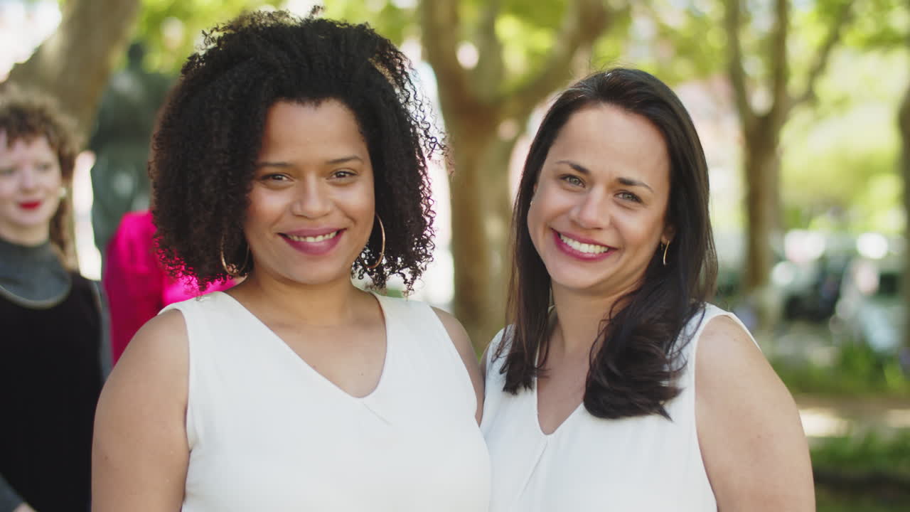 pareja de lesbianas besándose y mirando a la cámara durante la ceremonia de boda