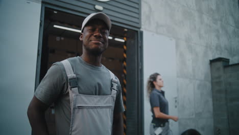 a smiling male warehouse or delivery worker at a loading dock