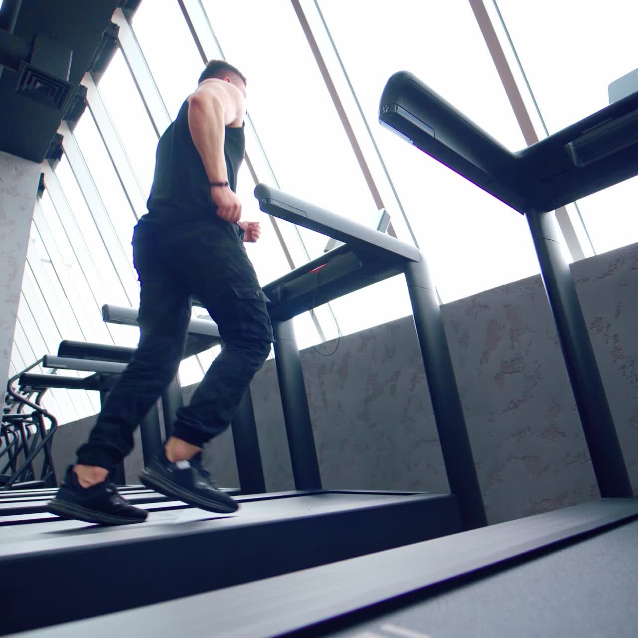 Sporty man running at gym. Fit man running on treadmill in the gym